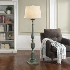 a living room with a chair, lamp and bookshelf