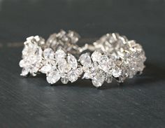 "I designed this statement bracelet for the bride who wants to sparkle on her wedding day! It is made with cubic zirconia and wired with lots of sparkly Swarovski crystals. It is .75\" or about 2 cm wide. The standard size of this bracelet is 7 inches and slightly adjustable. I make it by hand so if you need a different size you can indicate your wrist size or bracelet size in the note to seller. I love to customize so please contact me if you are interested in adding any gemstones! The earrings White Sparkling Diamond Bracelet For Wedding, Glamorous Diamond Wedding Bracelet, Glamorous Wedding Diamond Bracelet, Sparkling Diamond Wedding Bracelet, Glamorous Diamond Bracelet For Wedding, Glamorous Cubic Zirconia Wedding Bracelets, Glamorous Wedding Bracelets In Cubic Zirconia, Wedding Diamond White Crystal Bracelet, Wedding Crystal Diamond White Bracelet