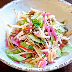 a white bowl filled with lots of food on top of a wooden table