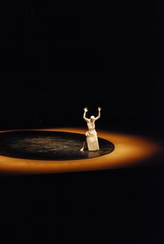 a woman standing on top of a black and white circle in the middle of a stage