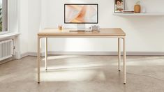 a computer monitor sitting on top of a wooden desk next to a radiator