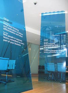 an office with two large blue glass panels on the wall