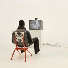 a man sitting in a chair watching tv