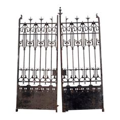 two metal gates with ornate designs on each one and the other side are facing opposite directions