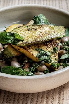 a white bowl filled with food on top of a table