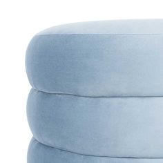 a round blue ottoman cushion sitting on top of a white floor