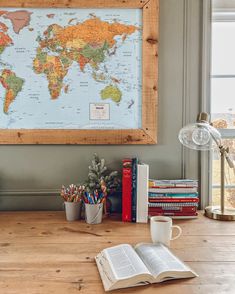 an open book on a wooden table next to a map