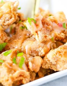 fried food on a plate with chopsticks and garnished with parsley