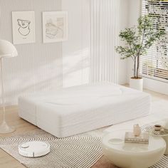 a living room with white furniture and decor on the walls, including a bed that has been made to look like a mattress