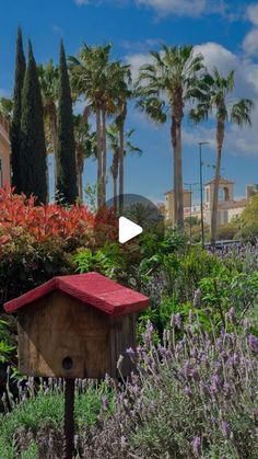 a bird house sitting in the middle of a garden