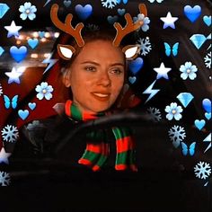 a woman with reindeer antlers on her head is in a car decorated for christmas