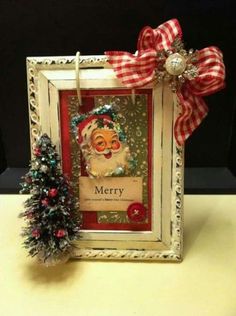 a christmas card with a small tree on the side and a red bow hanging from it