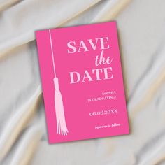 a pink save the date card with a tassel hanging from it's end