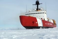 a large red and white boat in the snow