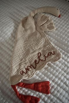 a baby's hat and mitten laying on top of a bed