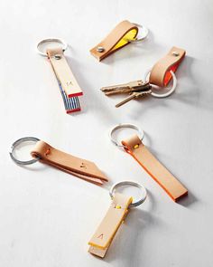 four different types of keychains on a white surface with one yellow light in the middle