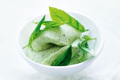 a white bowl filled with green leafy food