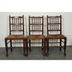 three wooden chairs sitting next to each other