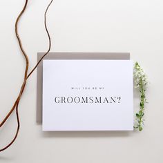 a card with the words will you be my groomsman? next to a flower