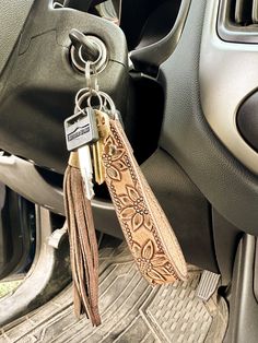 This tooled leather keychain is the perfect western accessory to keep track of your keys & make a statement, all at the same time. This keychain is handcrafted from scratch & tooled with care. It is finished with a silver rivet & stainless steel keyring. Due to the handmade nature of this item, the actual product may vary from the photo. All keychains are made to order, so they will be unique. Western Key Chain, Western Christmas Present Ideas, Tooled Leather Wristlet Keychain, Western Office Supplies, Christmas List Western, Western Stocking Stuffers, Western Car Accessories Cowgirl Bling, Western Steering Wheel Cover, Things To Make Out Of Leather