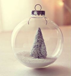 a snow covered christmas ornament with a small tree inside