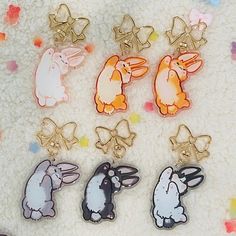 several different colored rabbit shaped pins on a white surface