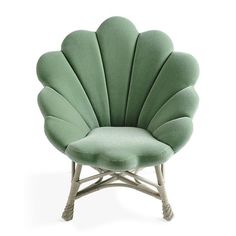 a green shell chair sitting on top of a white floor