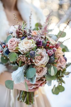 a bridal holding a bouquet of flowers and greenery