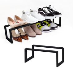 four pairs of shoes are sitting on a black metal shelf and one pair is white