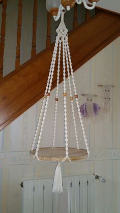 a white chandelier hanging from the ceiling in a room next to a stair case