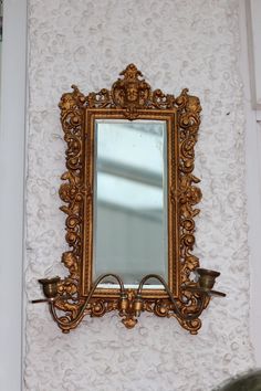 an ornate gold framed mirror on the wall