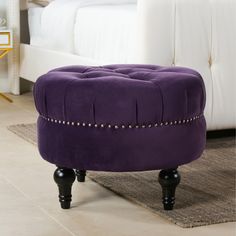 a purple ottoman sitting on top of a rug