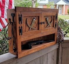 a wooden cabinet sitting on top of a porch next to an american flag in the background