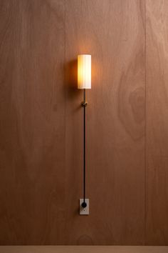 a lamp that is on the wall next to a wooden paneled wall and floor