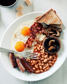 a white plate topped with eggs, beans and toast