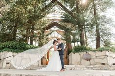 a bride and groom standing in front of a church