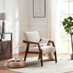 a living room with a chair, rug and potted plant on the side table