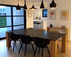 a dining room table and chairs in front of an open floor plan with sliding glass doors