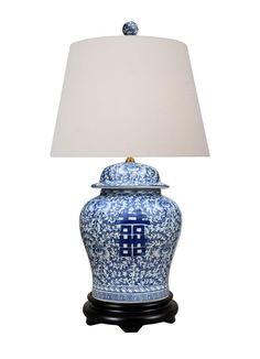 a blue and white vase with a lamp on it's side, against a white background