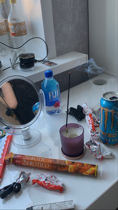 the vanity is cluttered with various items such as candles, toothbrushes and candy