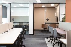 an office cubicle with desks and chairs in the middle, along with sliding glass doors