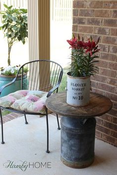 a flower pot sitting on top of a table next to a chair and planter