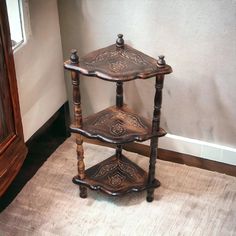 two tiered wooden shelf with carved designs on it