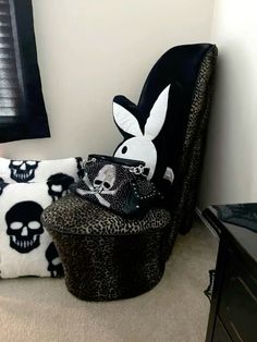 a chair with some pillows on it and a skull pillow in the corner next to it