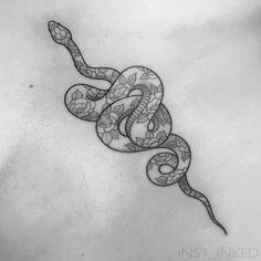 a snake tattoo on the back of a woman's stomach, with black and white ink