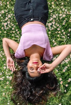 a woman laying on her back in the grass