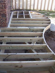 the bottom half of a house being built with wooden planks on top of it