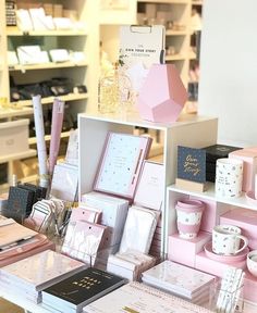 many different items are on display in the store, including pink and white boxes with gold trimmings