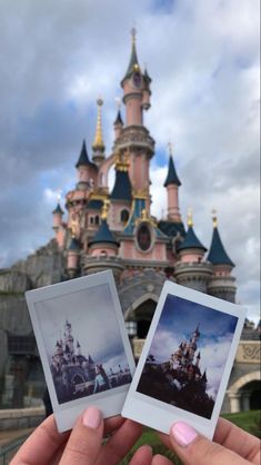 someone holding up two polaroid photos in front of a castle with the sky behind them