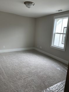 an empty room with a window and no curtains on the walls, is shown in this image